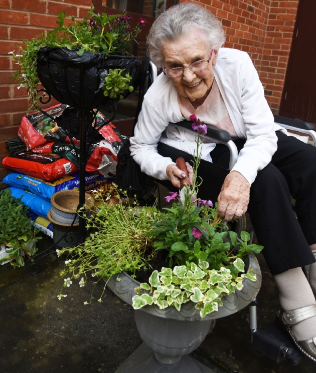 Betty McAteer planting some flowers