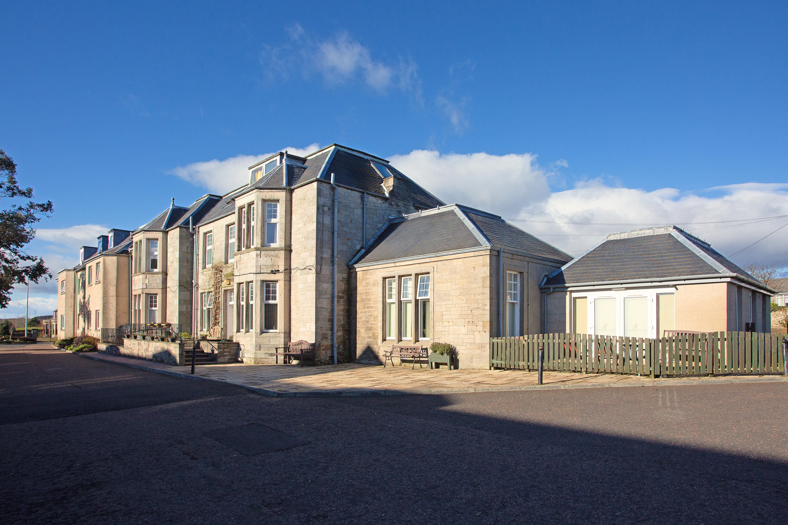 Craigie House Care Home pictured from the side on a sunny day with blue skies behind